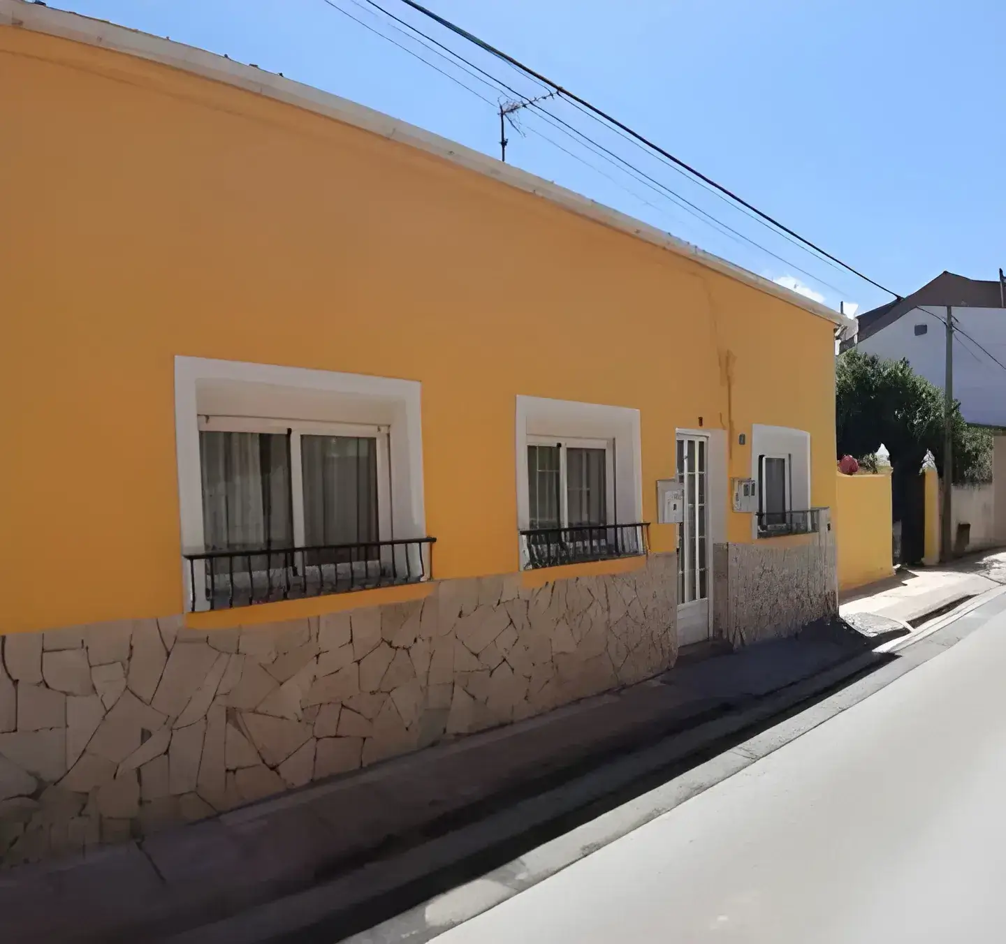 Los pintores Almería Fachada de casa tradicional pintada en color amarillo con zócalo de piedra