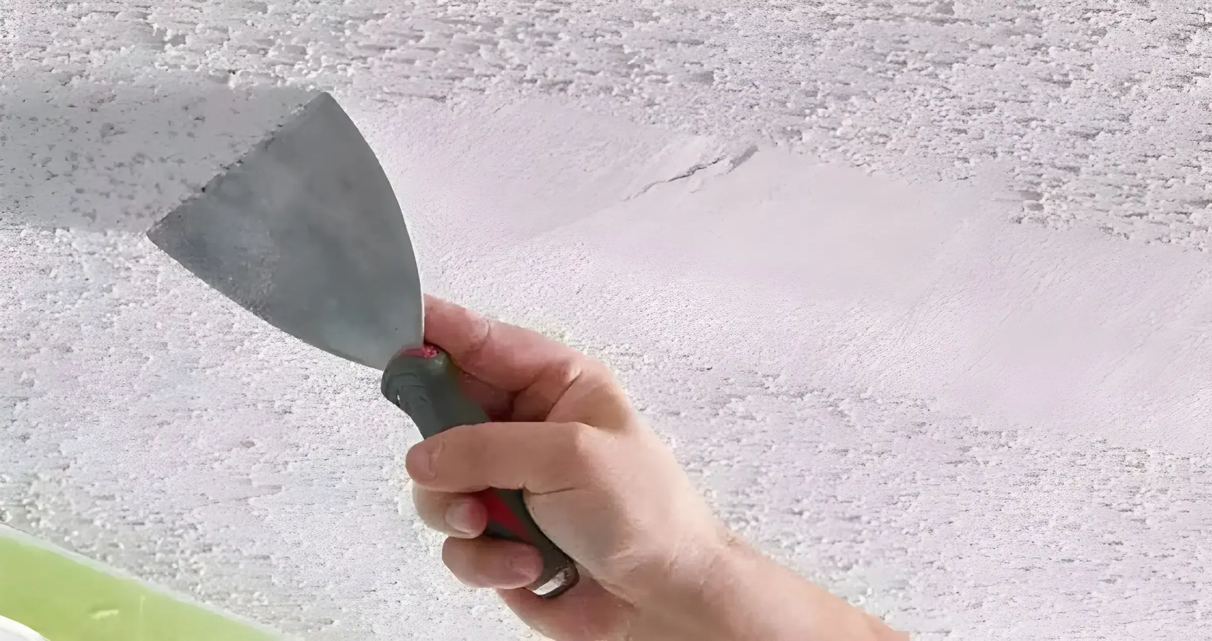 Los pintores Almería eliminando el gotelé con espátula para dejar la pared lisa